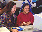 women laughing by computers