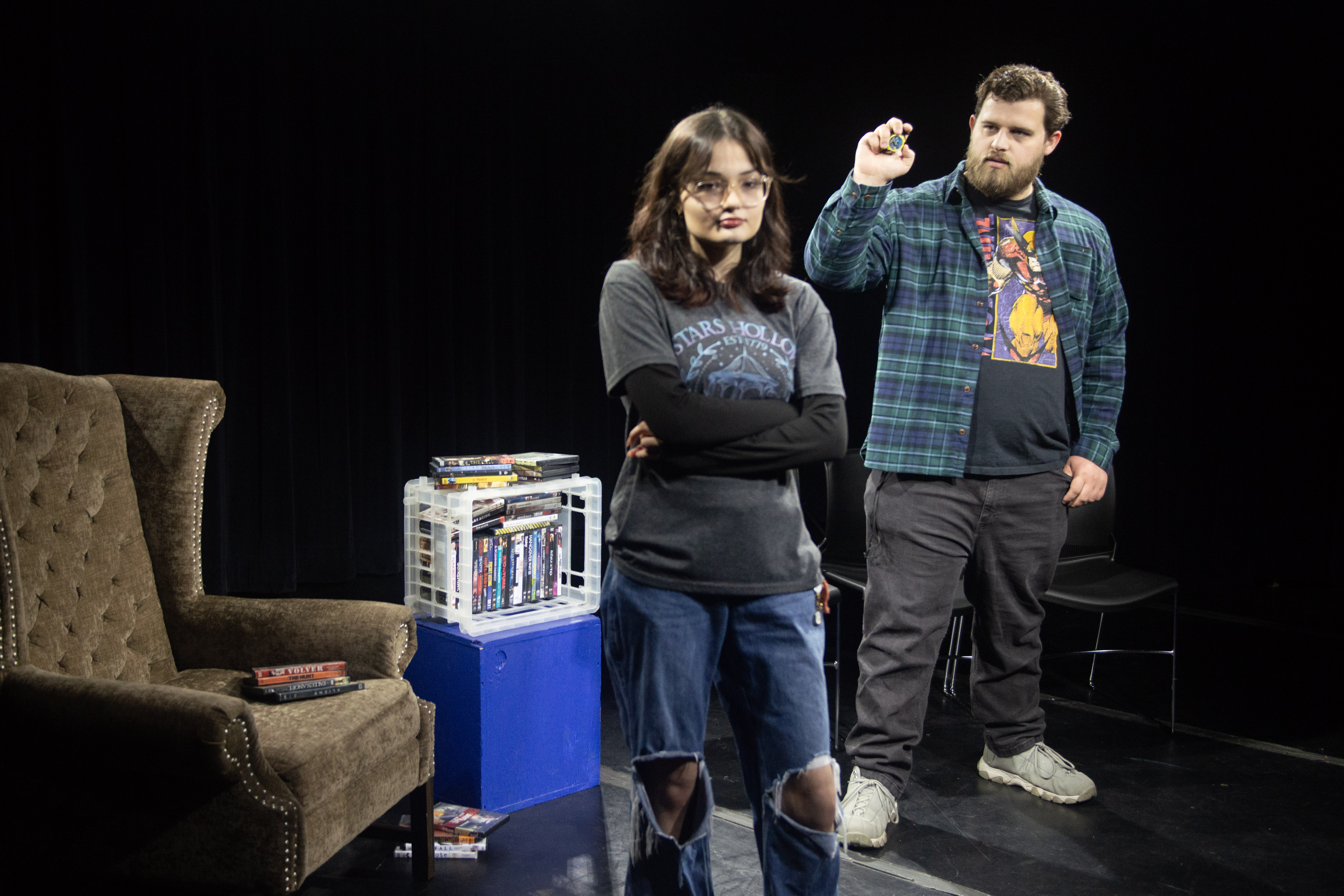 A man in a green flannel is pointing at a woman in grey shirt