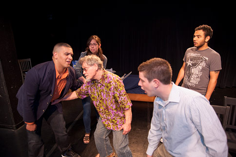 Five actors, one is being punched in the stomach