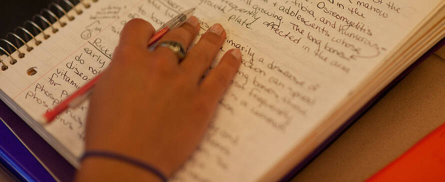 student writing in a notebook