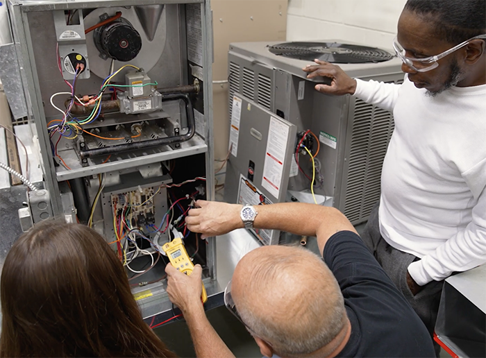 Students working on repairing an AC