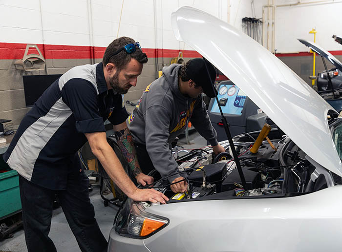 2 students working on a car engine