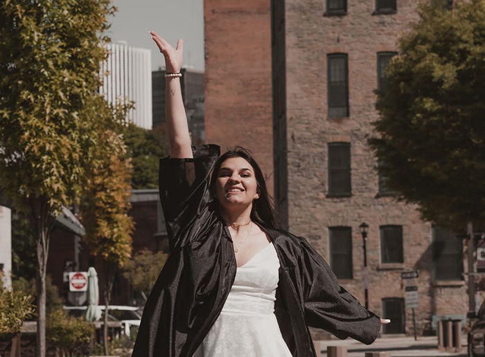 A girl in a white dress and a graduation gown