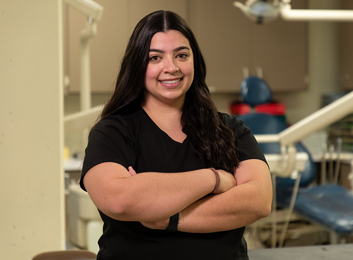 a student smiling in black scrubs