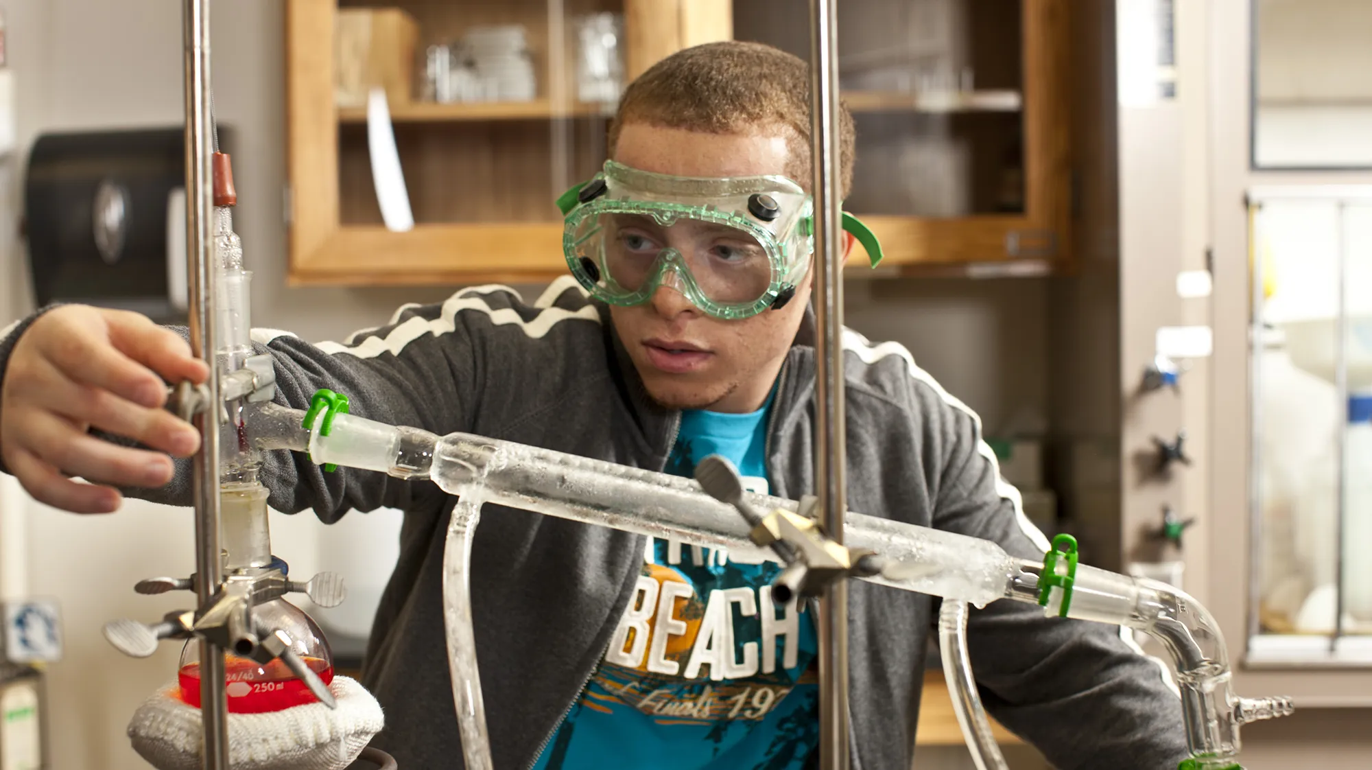 An MCC Biotechnology student wearing safety goggles works at a lab bench