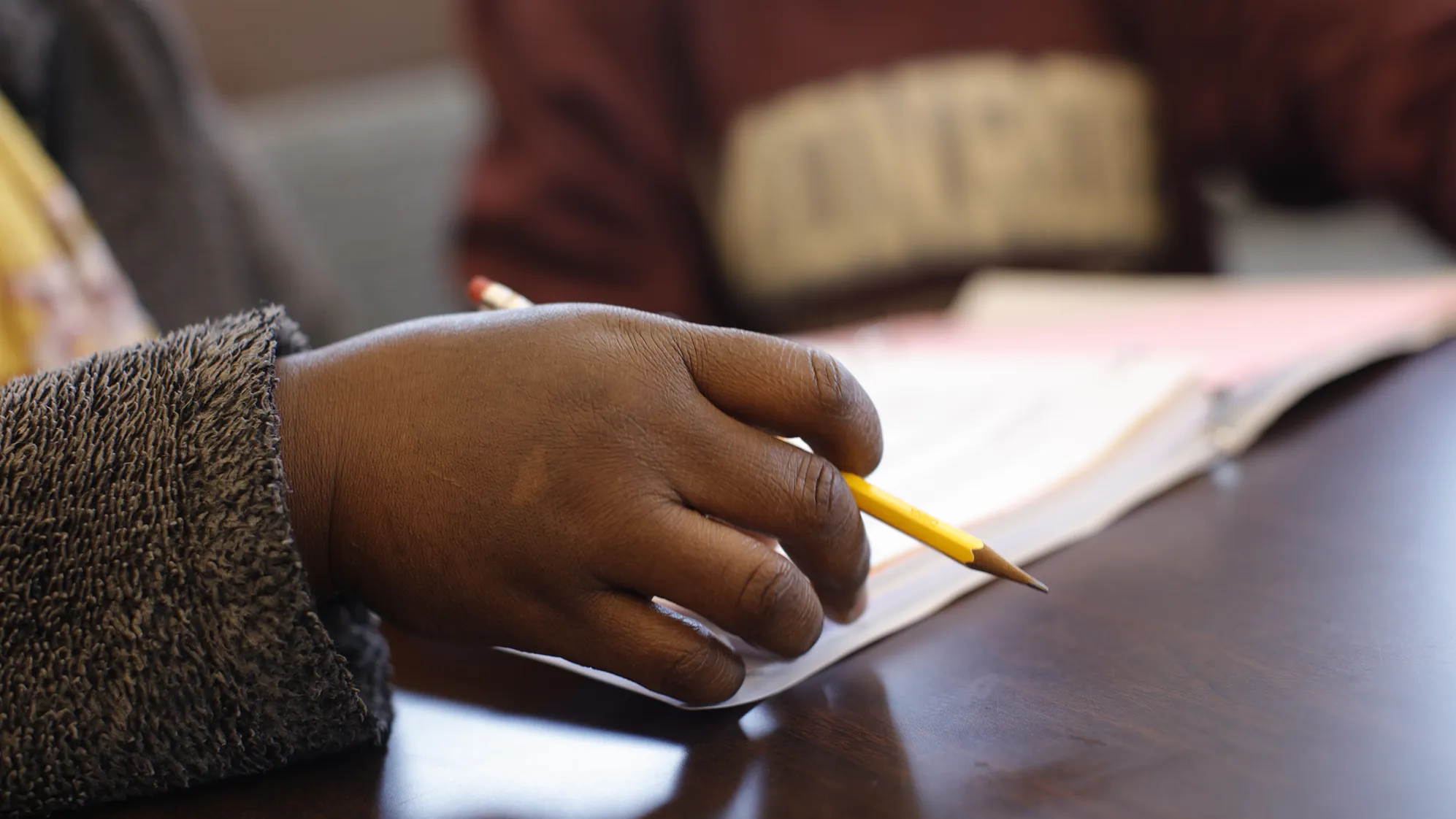 A hand holding a pencil prepares to write