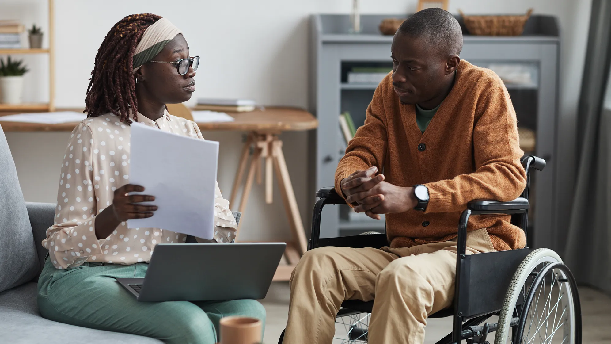 A counselor talks to a man in a wheelchair