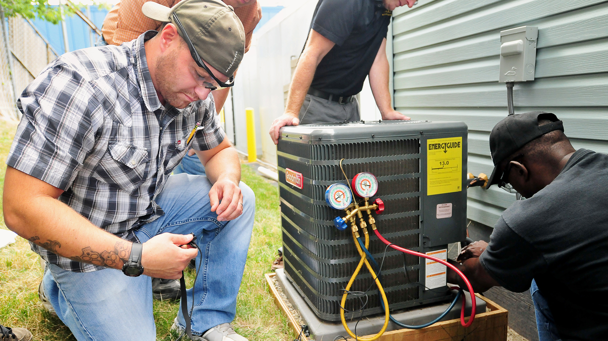 HVAC students gain hands-on experience installing and servicing an outdoor air conditioning unit as part of technical training.