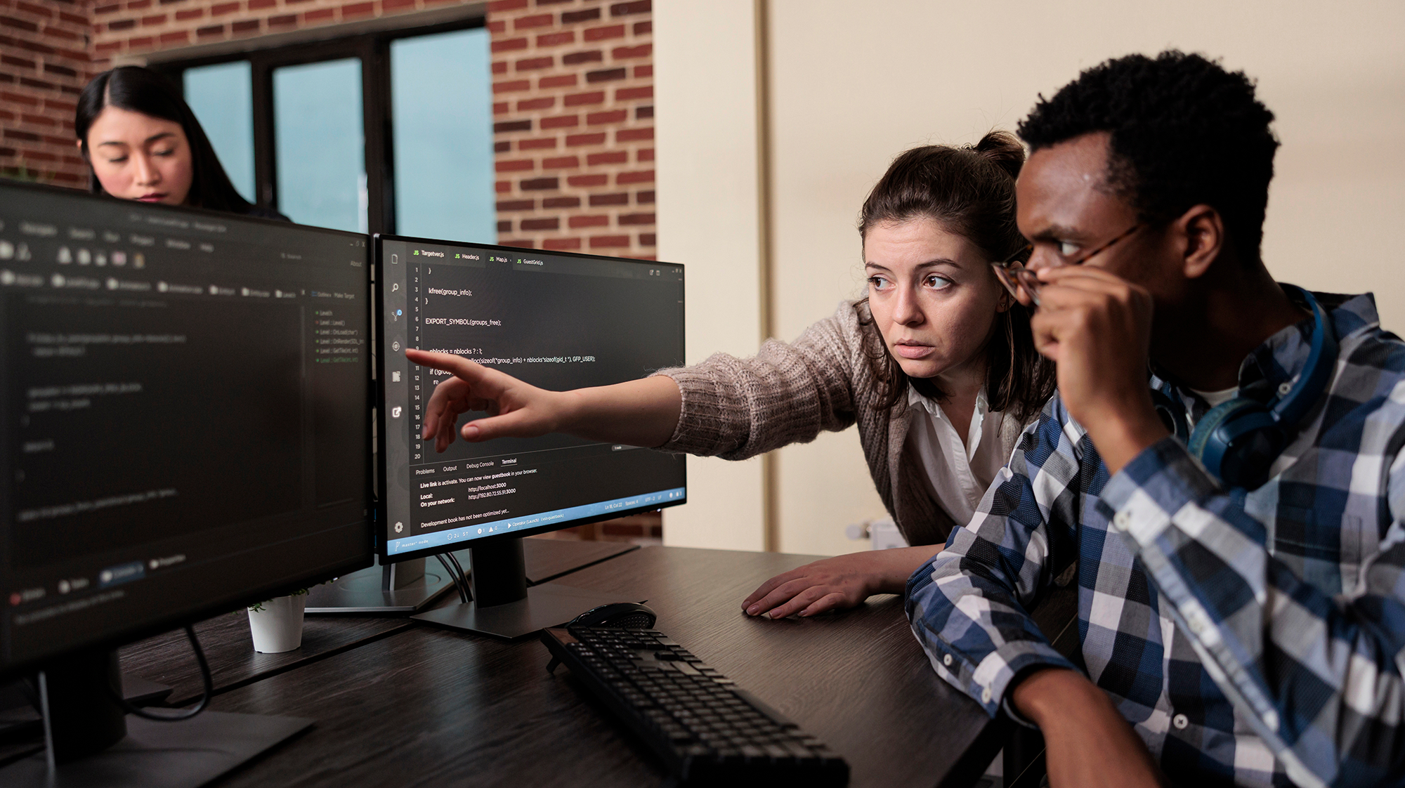 two people looking at code on a computer screen