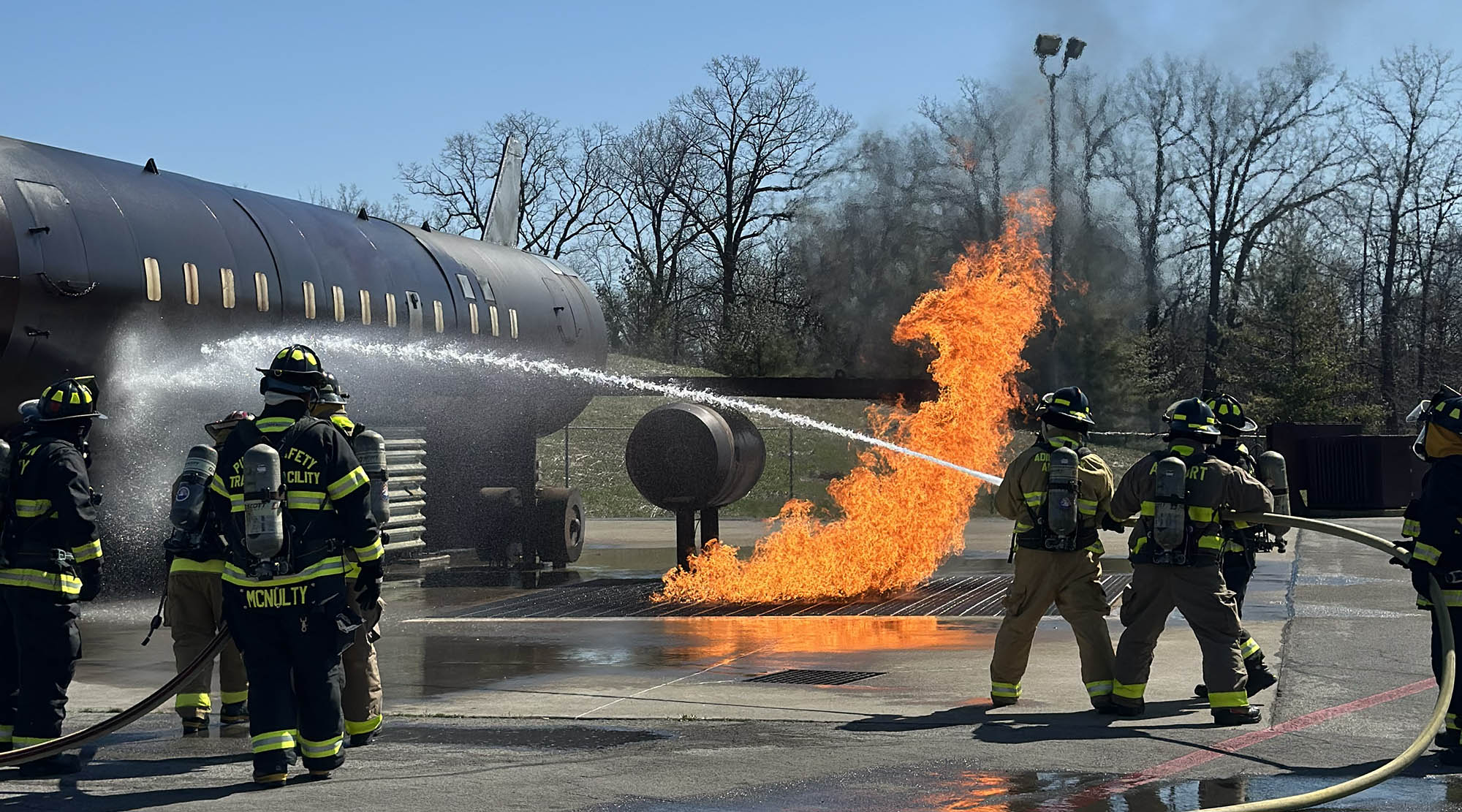 firefighters helping put out a fire on a plane