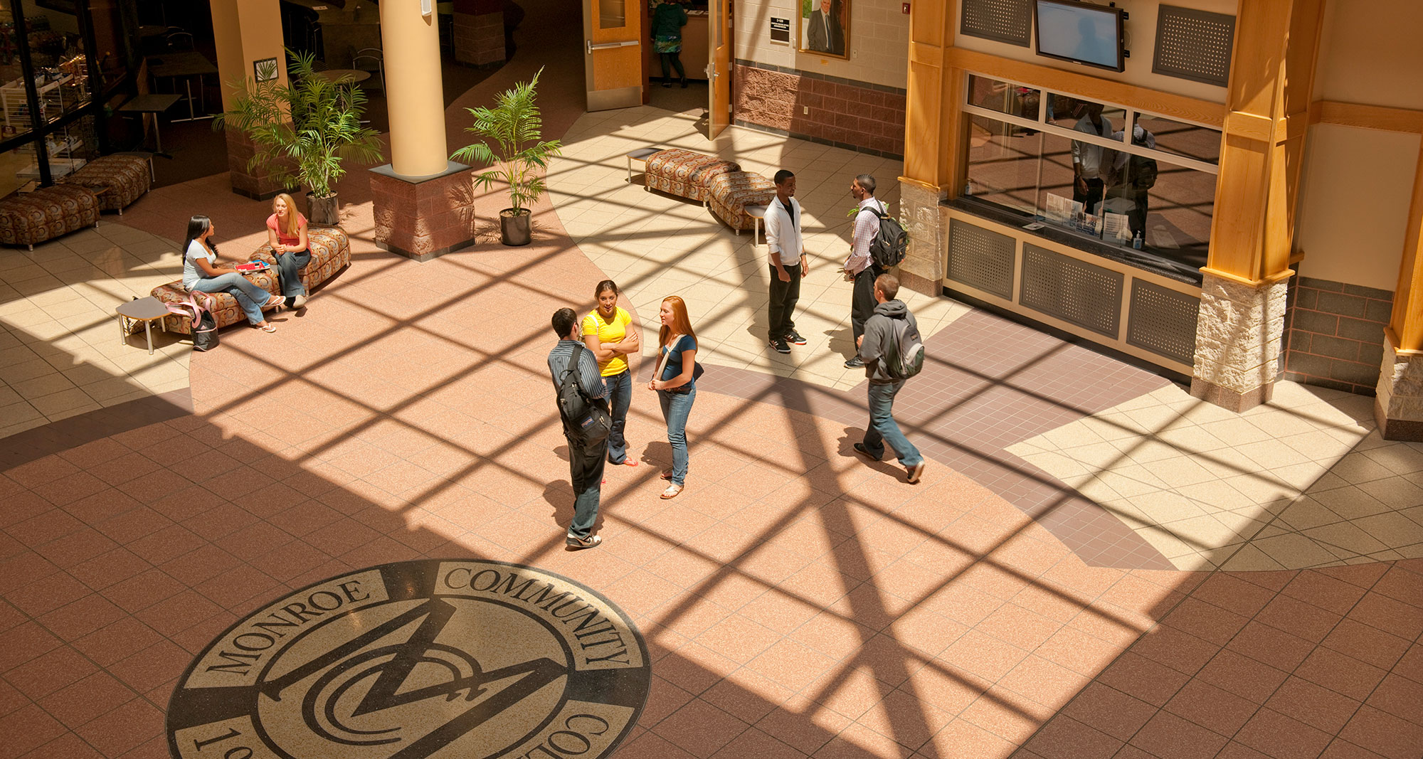 Photo of the campus atrium with students talking in the center.