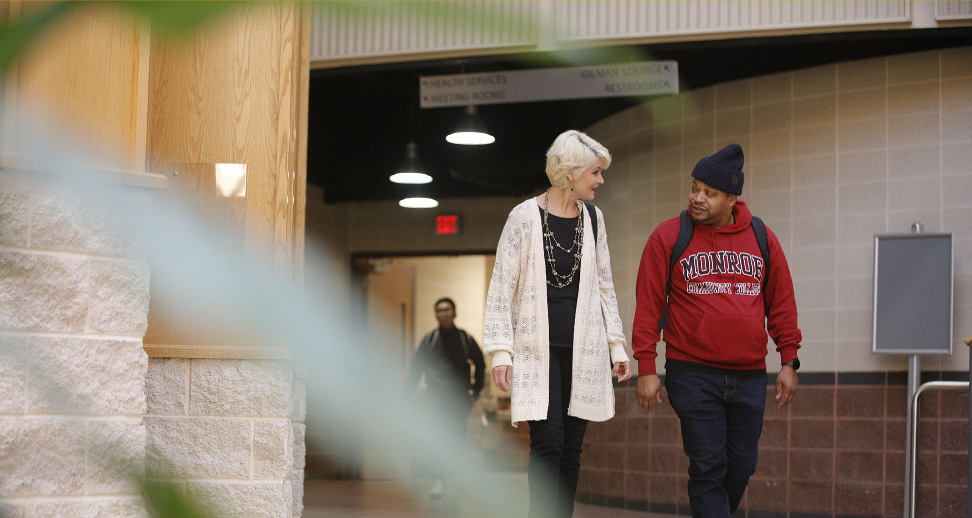 2 adult students walking in building 3