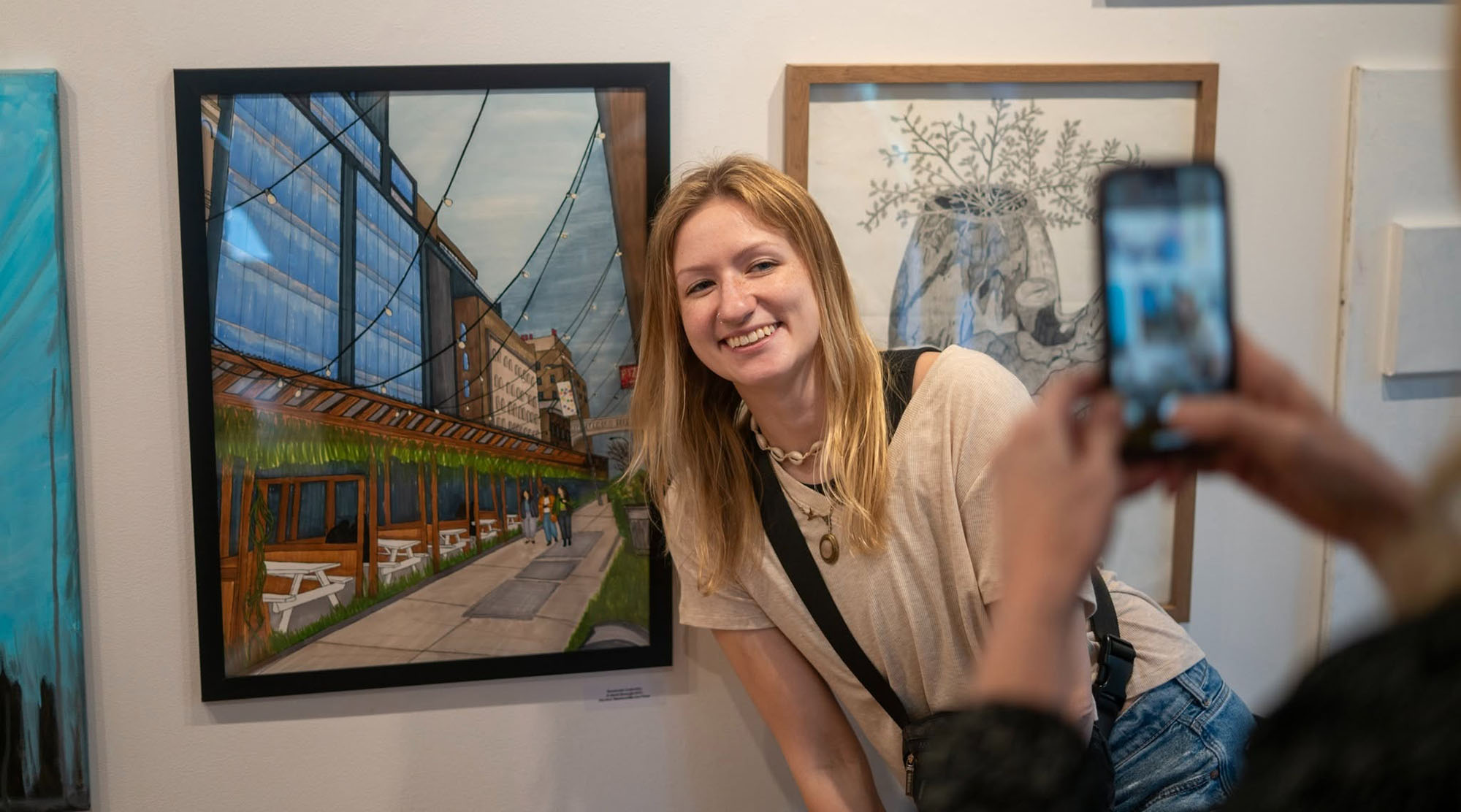 a student posing next to their artwork for a picture