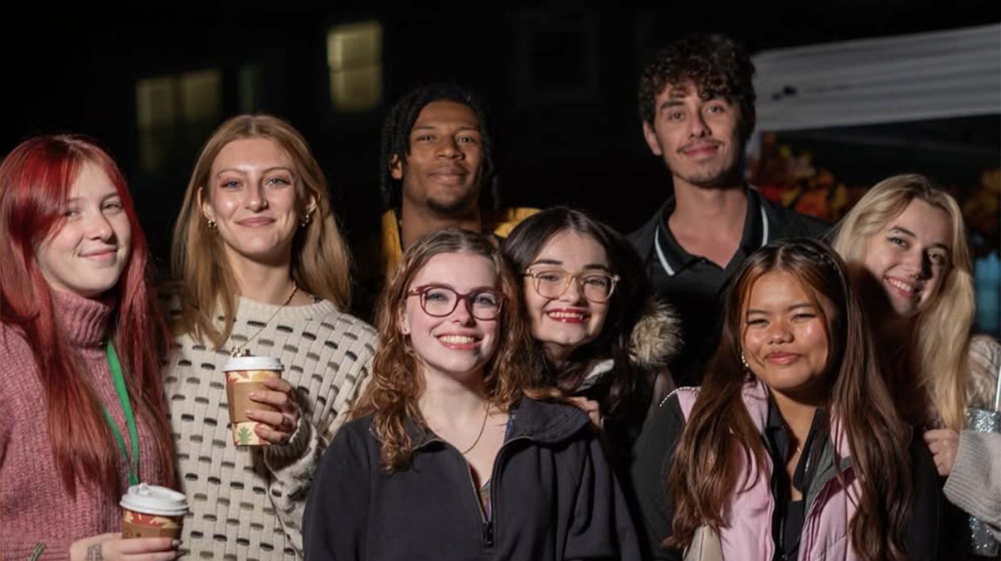 a group of students smiling and holding coffee