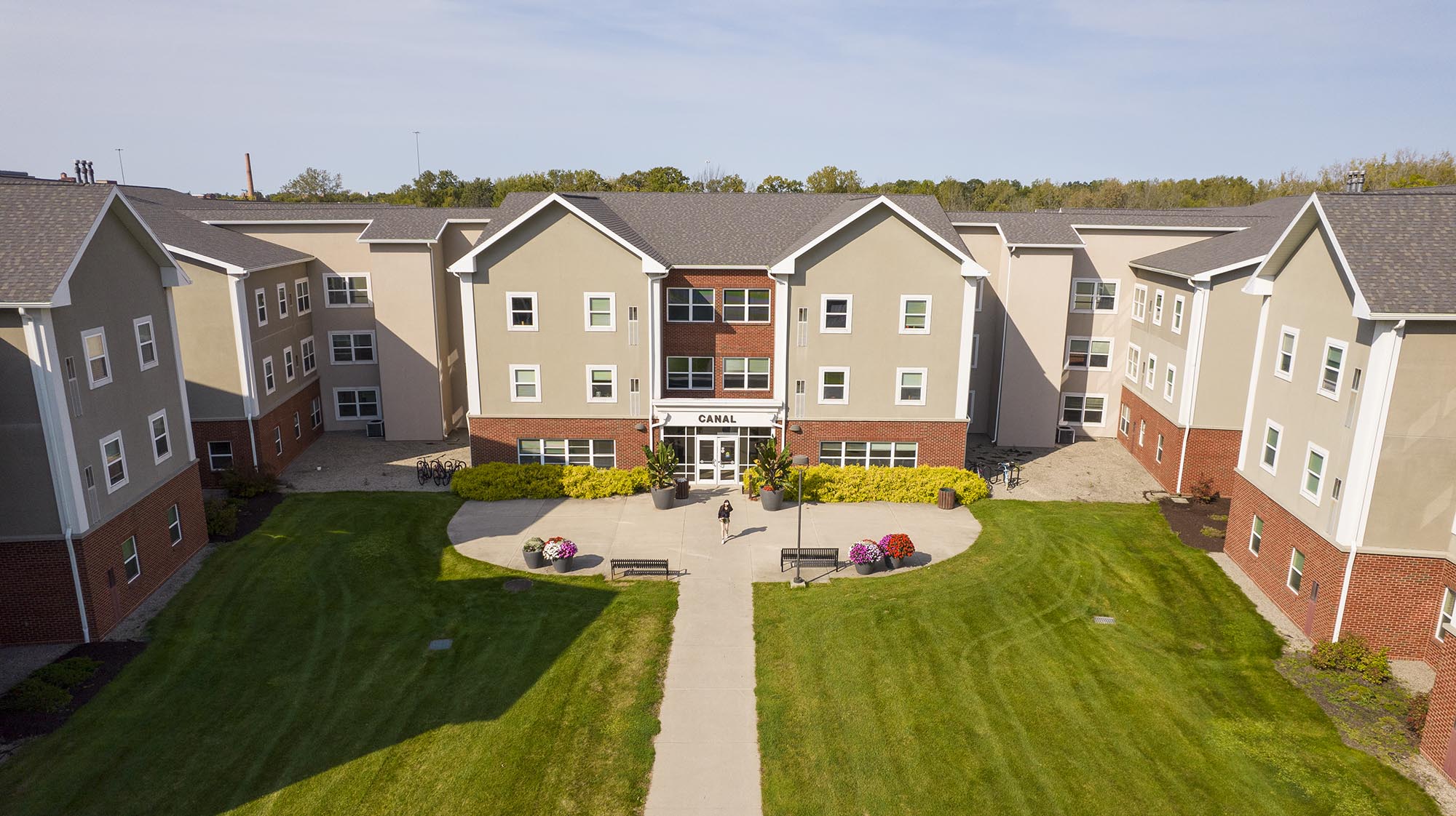 Aerial view of the Canal residence hall at Monroe Community College, surrounded by landscaped grounds and walkways.
