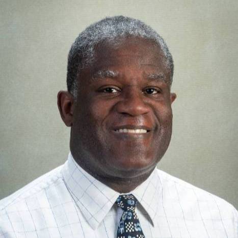 Headshot of Calvin Gantt smiling wearing a suit with tie.