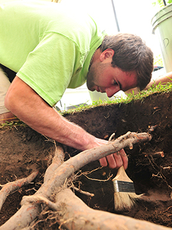 Male MCC student excavating a study site.