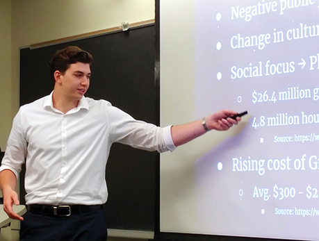 A male "Launch Your Business" program entrepreneur presenting to an audience.