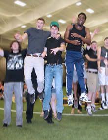 students in pac center jumping in the air