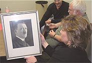 HGHRP member holding a photo of Hitler