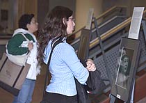 student in atrium viewing holocaust posters