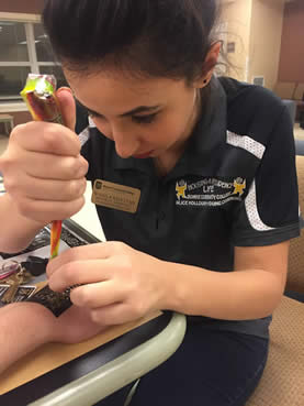 student getting a henna tattoo