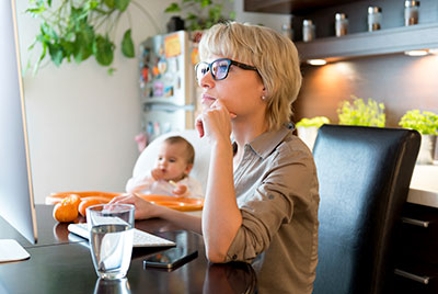 Student studying in chair with child in the background