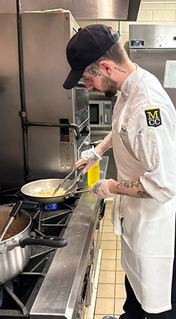 Students cooking at a stove in the food for thought kitchens