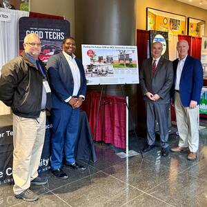 Doug Rivers and Robin Cole Jr. of MCC with John Love and Brad McAreavy of the Rochester Automotive Dealers Association pose with a rendering of the new ATC Building.