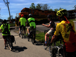 MCC Cycling Council waiting on their bikes for a train to pass