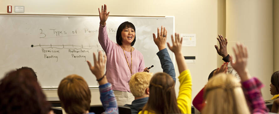 Prof. Lena Shiao speaking before a class of students.