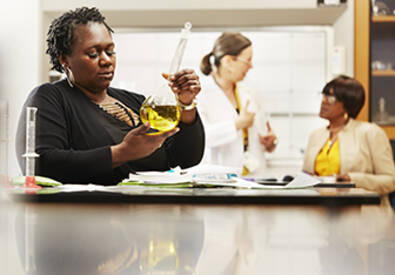 Two students working with MCC professor in Downtown Campus chemistry lab