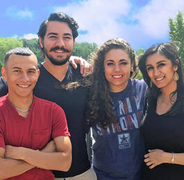 Students smiling and happy with sky in the background