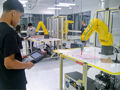 Students operating FANUC robots in a Forward Center lab