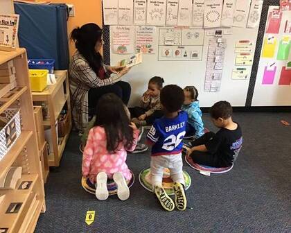 Children being read a book by a teacher