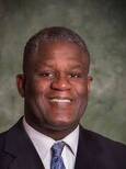 Headshot of Calvin Gantt smiling wearing a suit with tie.