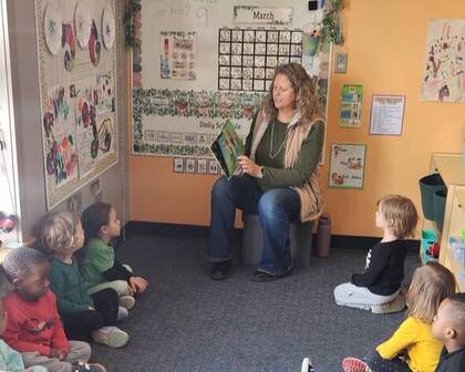 Children being read a book by a teacher