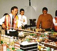 Photo of staff and faculty pointing to model of MCC