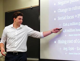 A male "Launch Your Business" program entrepreneur presenting to an audience.