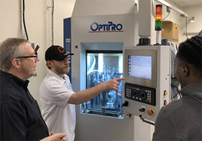 Professor working with MCC students at OptiPro machine