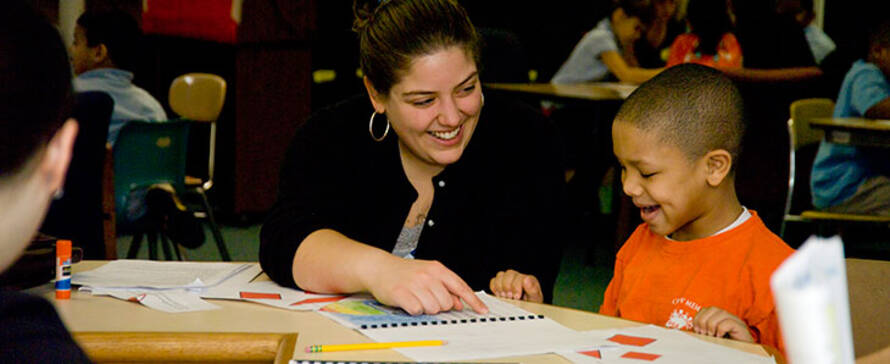 Photo of female student working with a young child