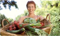 Woman with basket of freshly harvested vegetables