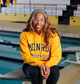 Jalisia Burno, MCC scholarship recipient posing at MCC swimming pool.