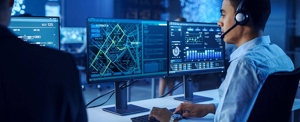 Individual reviewing digital maps on computer screen