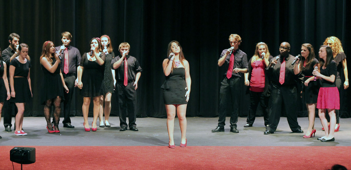 MCC co-ed vocal ensemble performing on stage.